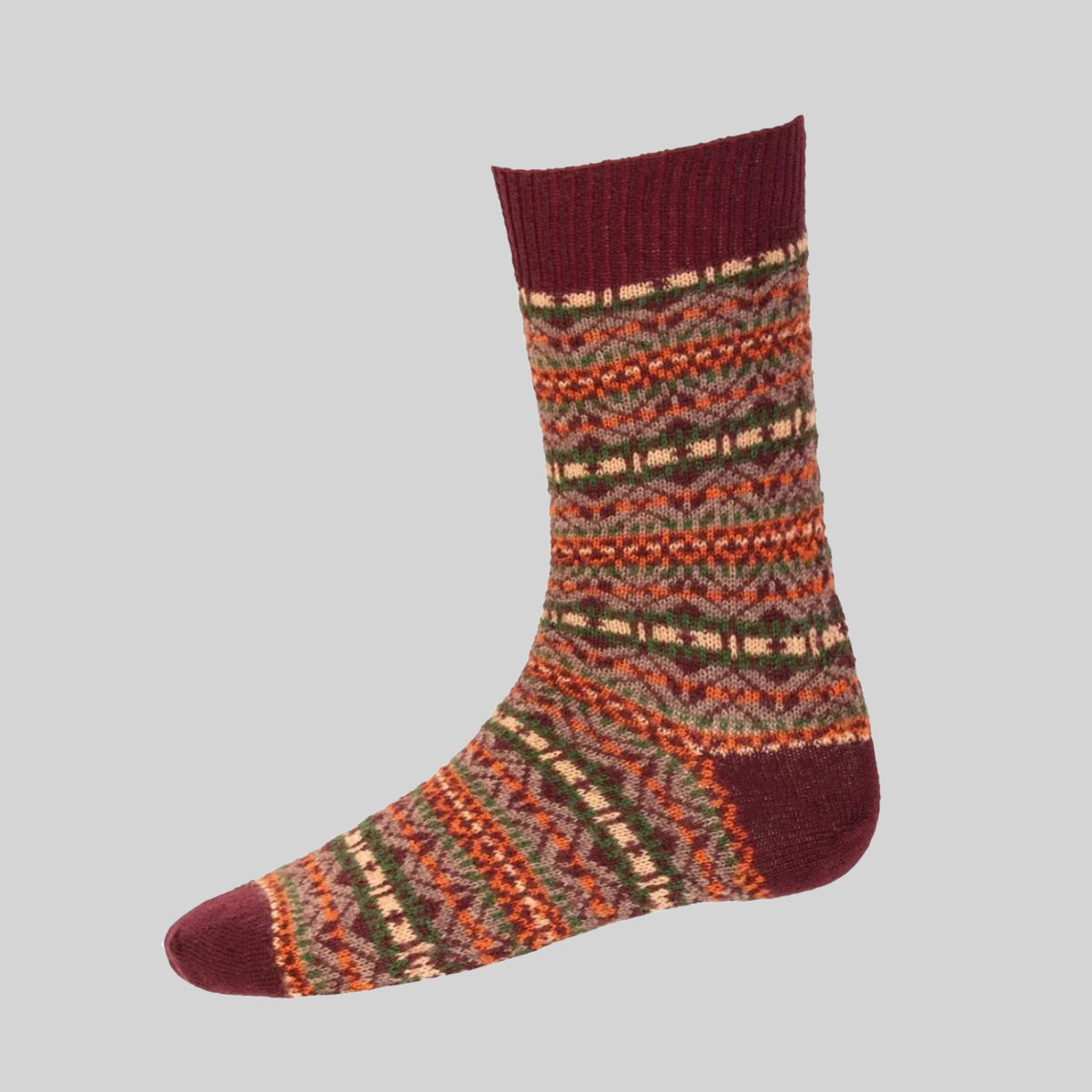 A single crew sock with a multicolor Fair Isle pattern in burgundy, rust orange, olive green, and cream, shown against a solid light gray background.