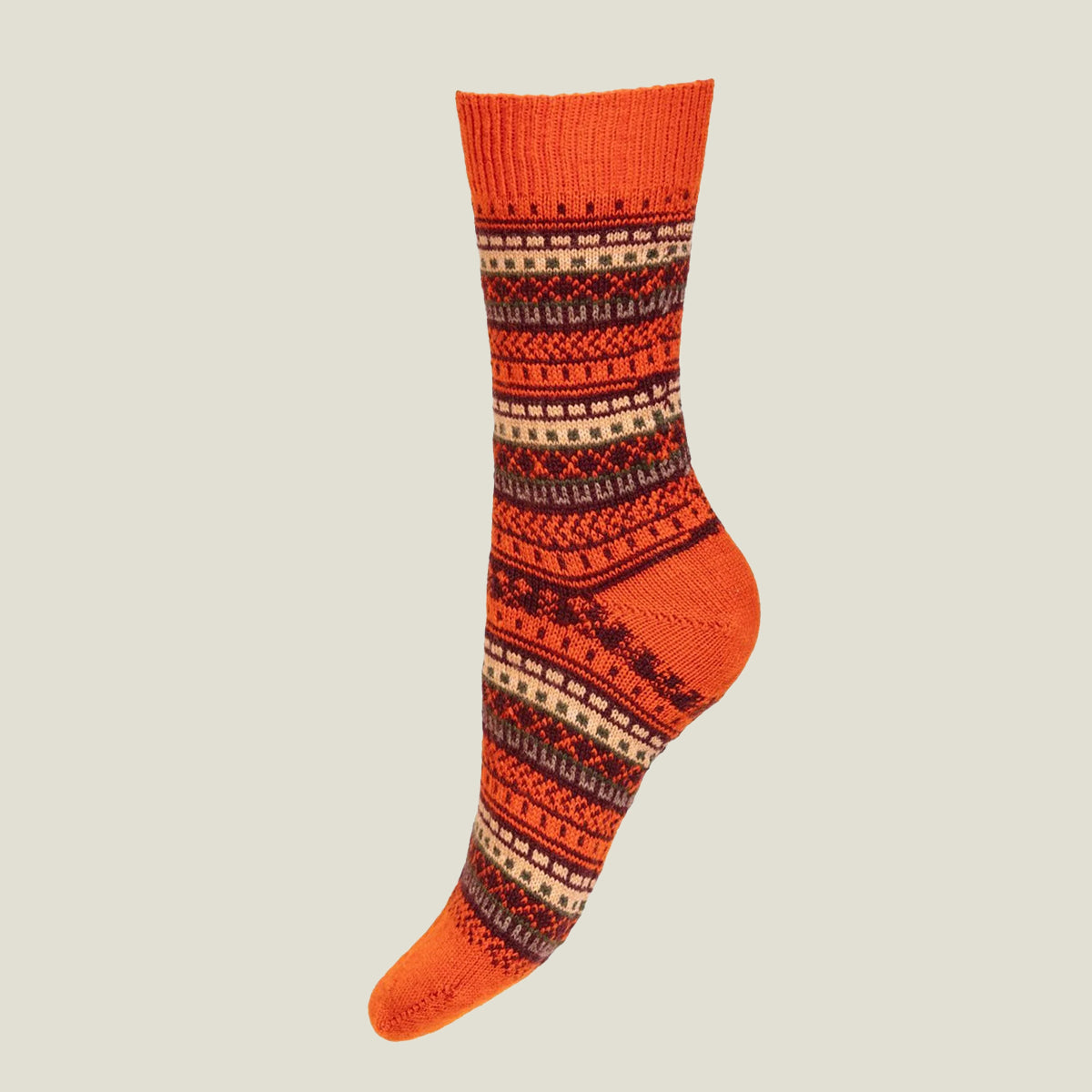 A single crew merino wool sock with a vibrant boom orange base and a detailed multicolor Fair Isle pattern in dark brown and cream, shown against a solid light gray background.