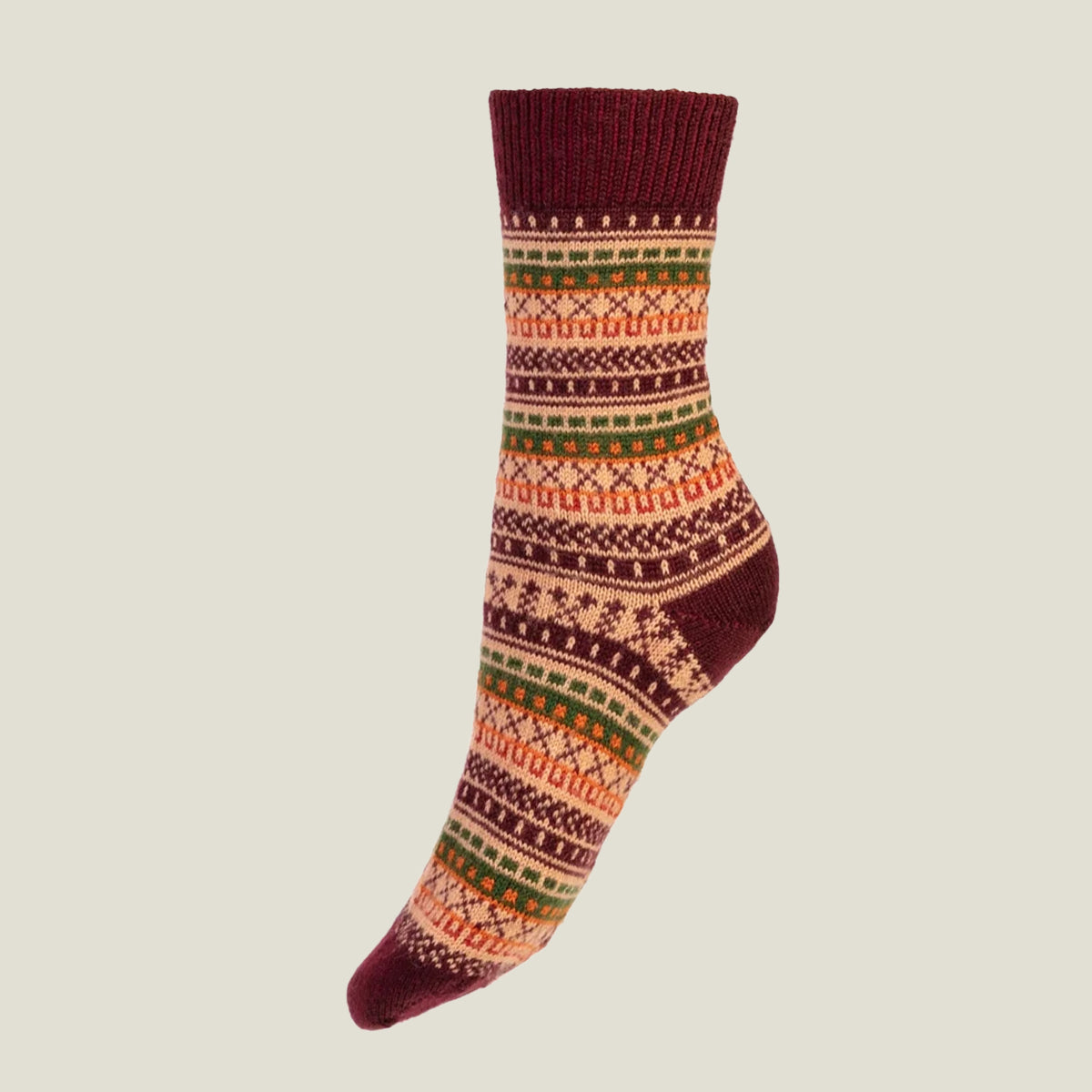 A single crew merino wool sock with a multicolor Fair Isle pattern in burgundy, orange, green, and cream, shown against a solid light gray background.