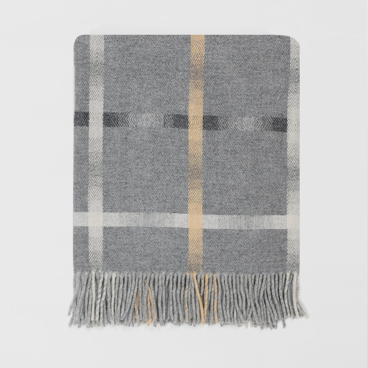 A grey lambswool merino plaid throw blanket with a vertical tan stripe and grey horizotonal stripe with fringed edges, displayed flat against a light grey background.
