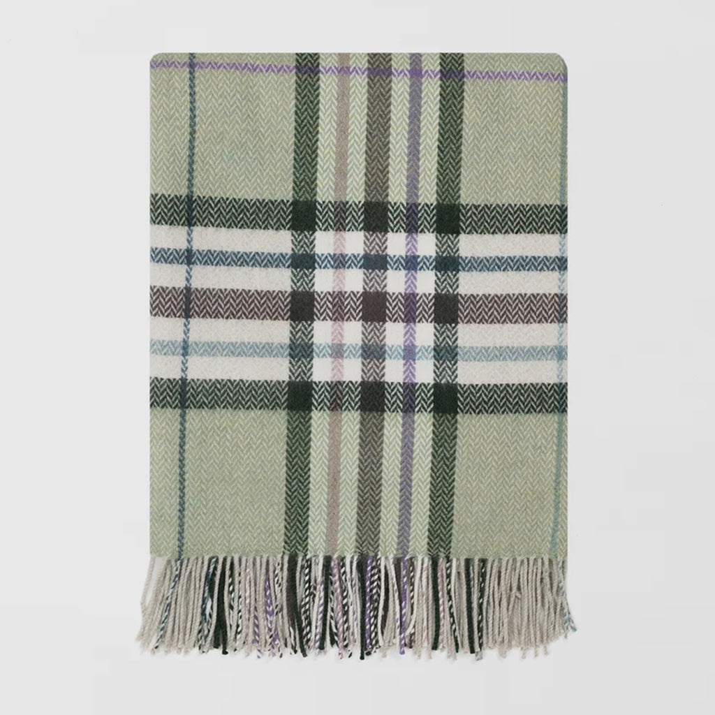 A close up of a merino lambswool Remony herringbone throw with a large check design, in jade green with a darker green and brown overcheck.