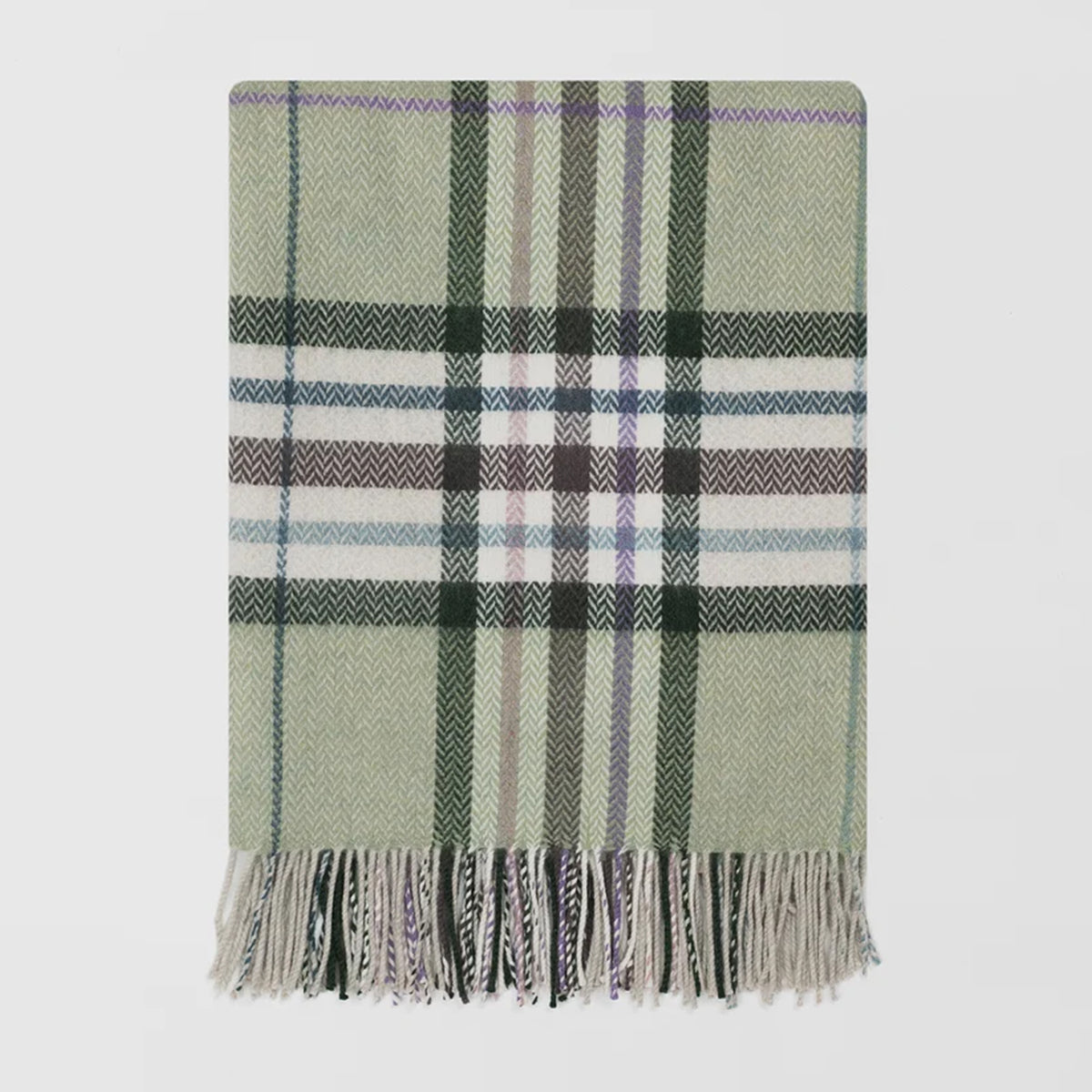 A close up of a merino lambswool Remony herringbone throw with a large check design, in jade green with a darker green and brown overcheck.