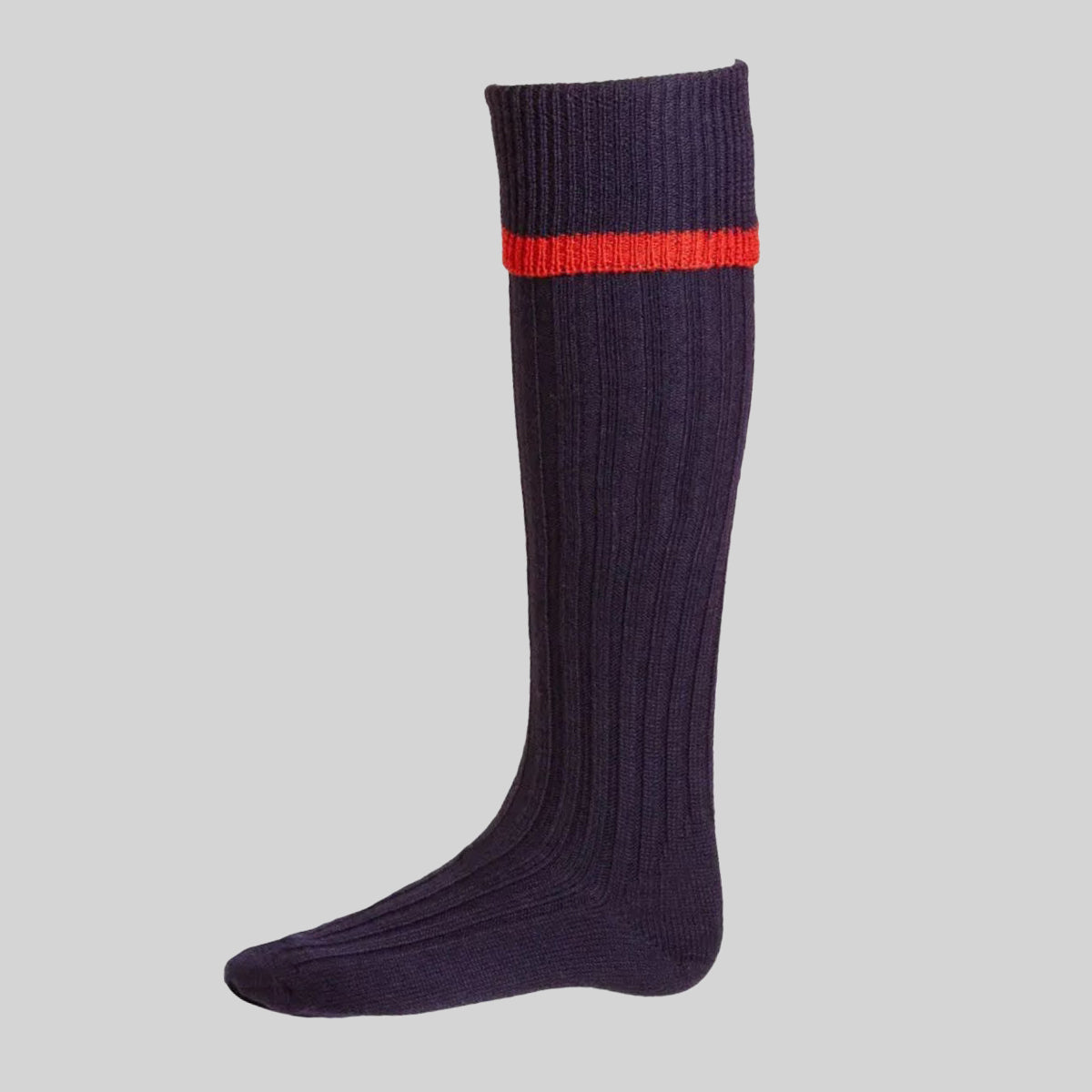 A single ribbed knee-high sock in dark navy blue with a thin red stripe around the cuff, shown against a solid light grey background.